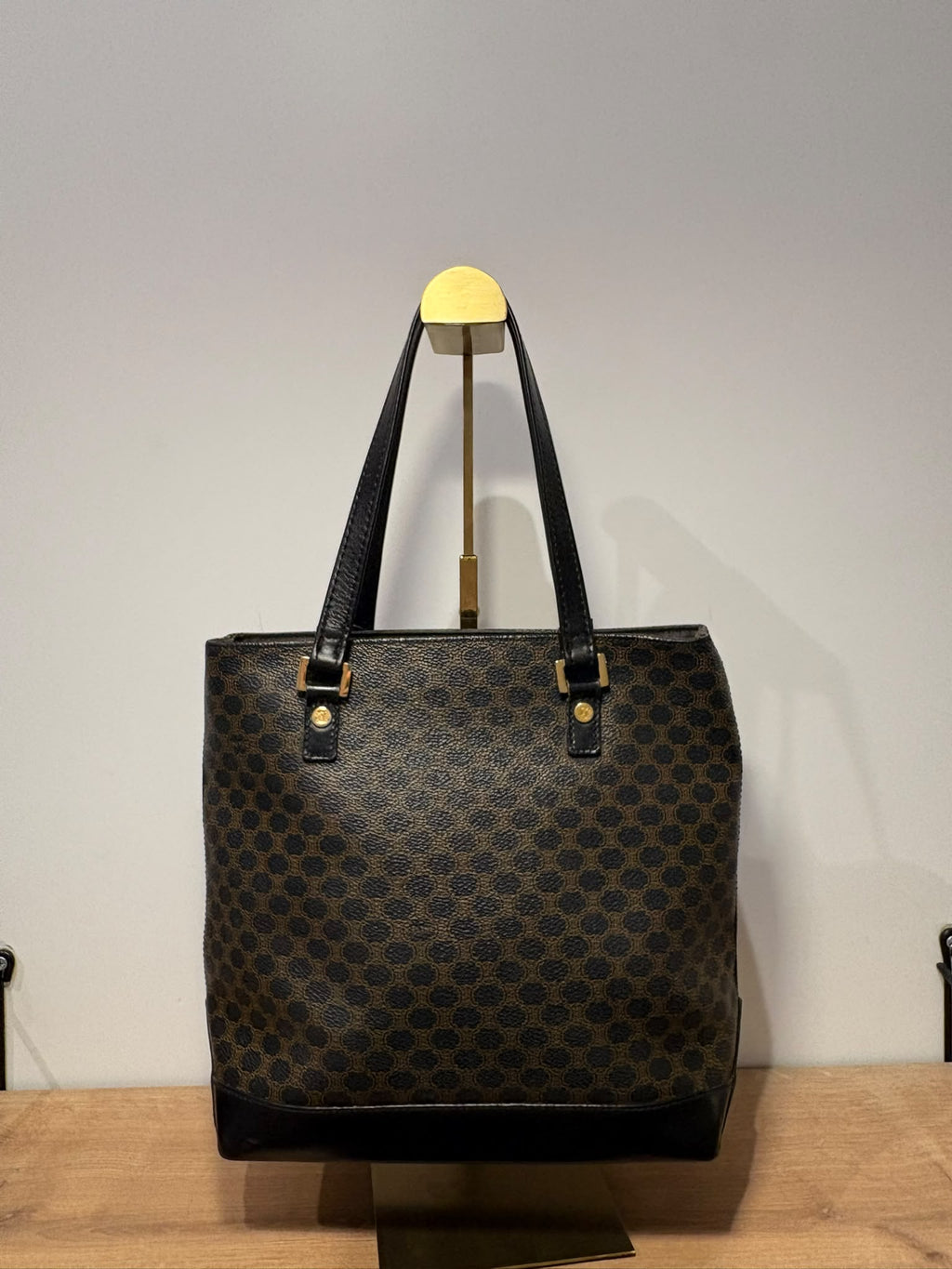 Celine tote Macadam sobre soporte con base negra y dos asas largas, vista frontal