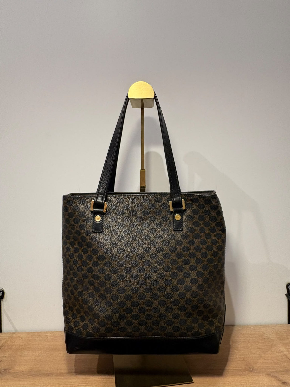 Celine tote Macadam sobre soporte con base negra y dos asas largas, vista frontal