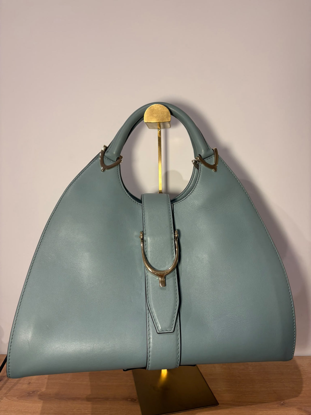 Gucci Stirrup con dos asas y cierre de estribo sobre soporte, vista frontal