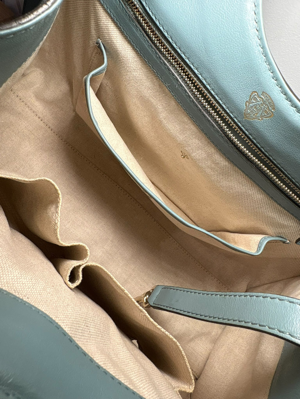 Gucci Stirrup, interior con forro beige, bolsillos abiertos y bolsillo con cremallera