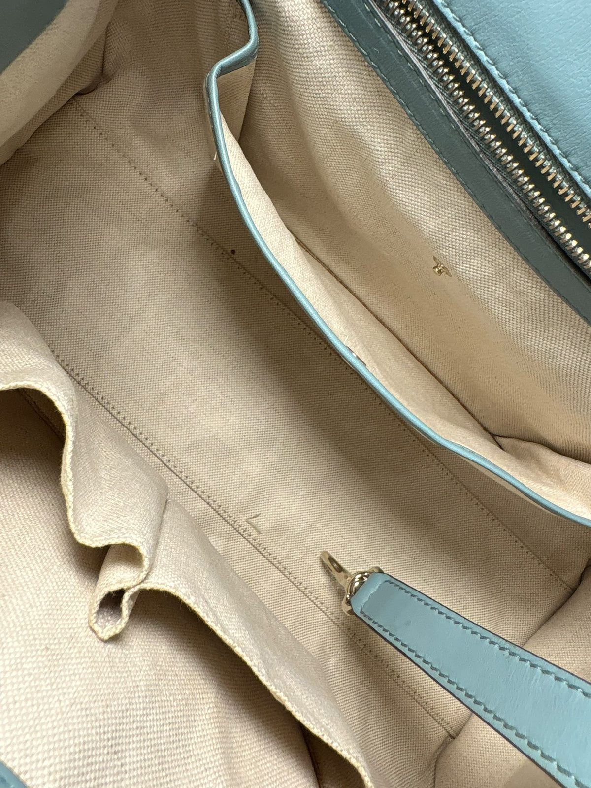 Gucci Stirrup, detalle del forro beige, bolsillos interiores y correa de piel con mosquetón